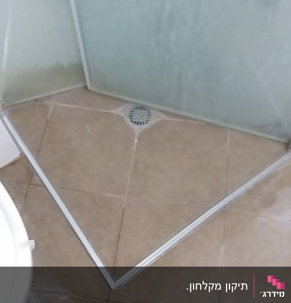 פינת מקלחת עם רצפת אריחים וניקוז